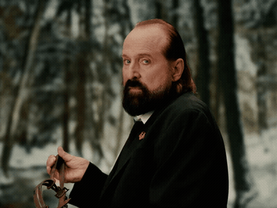 A Man With A Beard Is Holding A Leash In His Hands GIF