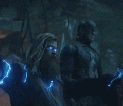 A Man With A Beard Is Holding A Lightning Hammer GIF
