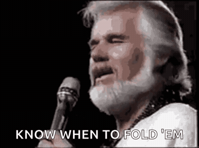 A Man With A Beard Is Holding A Microphone And Singing . GIF