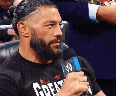 A Man With A Beard Is Holding A Microphone And Wearing A T-Shirt That Says Great GIF