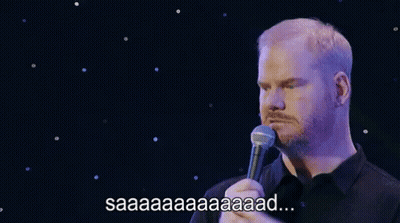 A Man With A Beard Is Holding A Microphone In Front Of Him And Saying Saaa . GIF