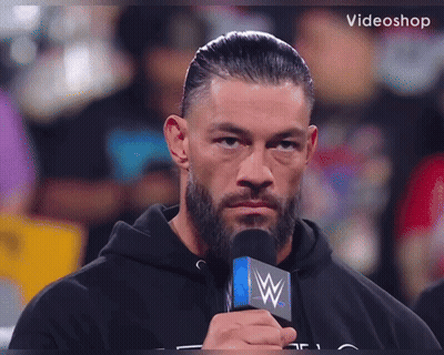 A Man With A Beard Is Holding A Microphone With A W On It GIF