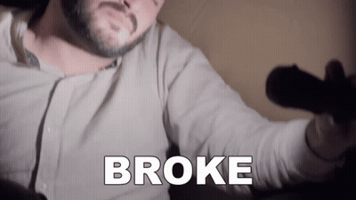 A Man With A Beard Is Holding A Microphone With The Word Broke Written On It GIF