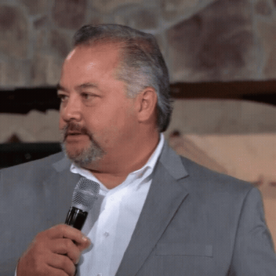 A Man With A Beard Is Holding A Microphone GIF