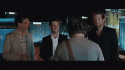 A Man With A Beard Is Holding A Piece Of Paper In Front Of A Casino . GIF