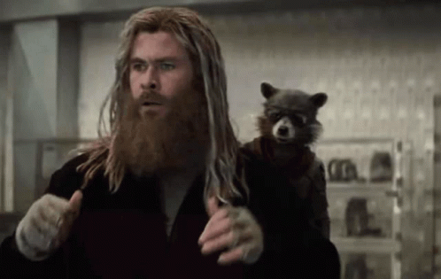 A Man With A Beard Is Holding A Raccoon On His Shoulders . GIF