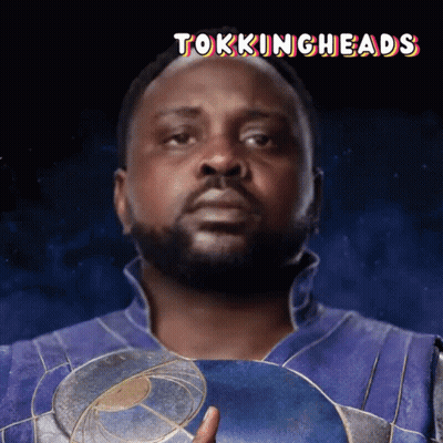 A Man With A Beard Is Holding A Shield With The Words Tokingheads Below Him GIF