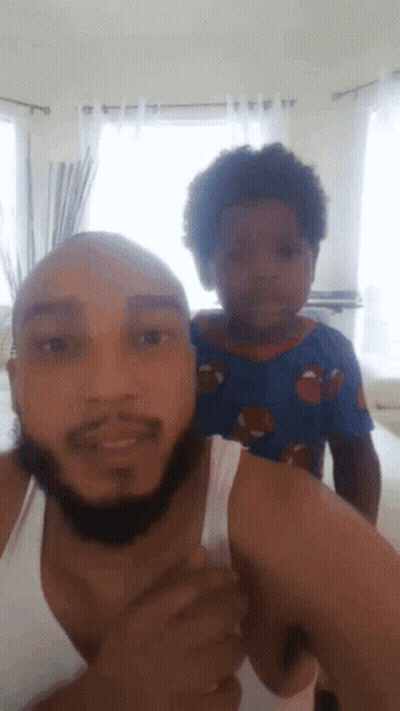 A Man With A Beard Is Holding A Small Child On His Shoulders GIF