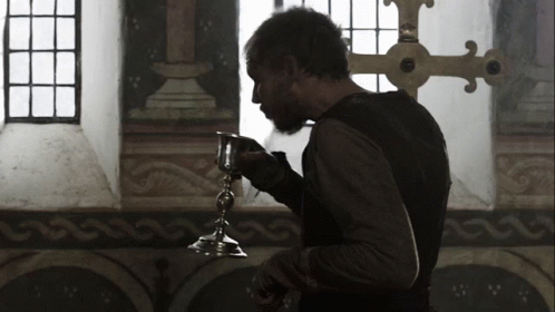 A Man With A Beard Is Holding A Small Silver Object GIF
