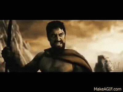 A Man With A Beard Is Holding A Sword In A Battle Scene From The Movie 300 . GIF