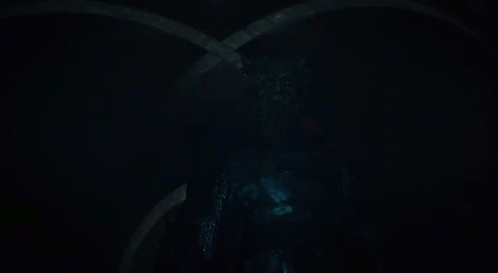 A Man With A Beard Is Holding A Sword In His Hand GIF