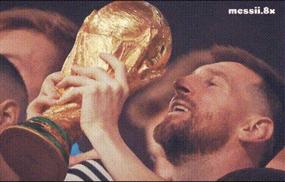 A Man With A Beard Is Holding A Trophy In His Hands In Front Of A Crowd . GIF