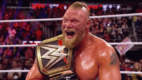 A Man With A Beard Is Holding A Wrestling Championship Belt In A Ring GIF