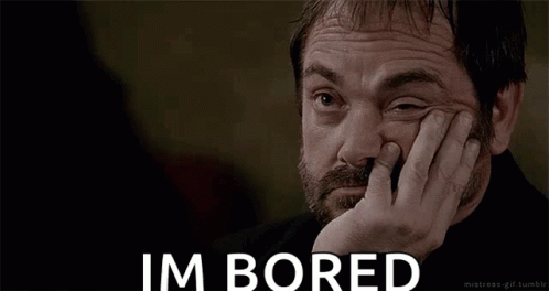 A Man With A Beard Is Holding His Hand To His Face And Says Im Bored GIF