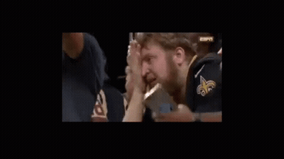 A Man With A Beard Is Holding His Nose While Watching A Game . GIF