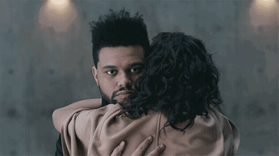A Man With A Beard Is Hugging A Woman With Curly Hair .. GIF