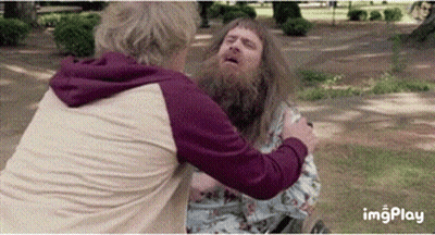 A Man With A Beard Is Hugging Another Man GIF