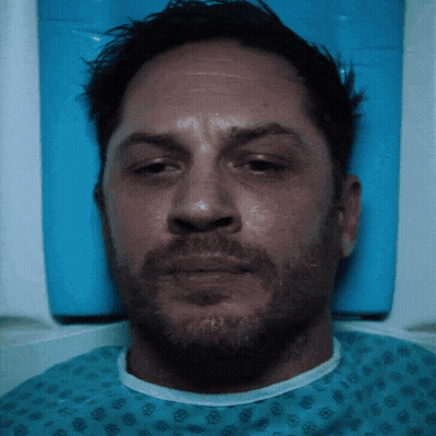 A Man With A Beard Is In A Hospital Gown GIF