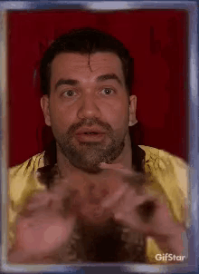 A Man With A Beard Is In A Picture Frame With Gifstar Written On It . GIF