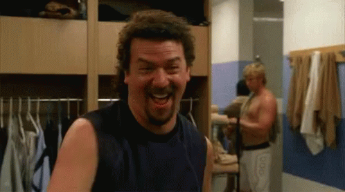 A Man With A Beard Is Laughing In A Dressing Room GIF