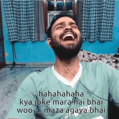 A Man With A Beard Is Laughing While Wearing A Green Shirt That Says Adidas On It GIF