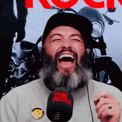 A Man With A Beard Is Laughing While Wearing Headphones And A Hat With The Word Rock On It GIF