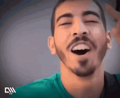 A Man With A Beard Is Laughing With His Eyes Closed . GIF