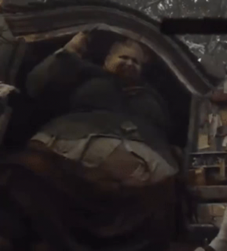 A Man With A Beard Is Laying Down In A Chair GIF