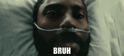 A Man With A Beard Is Laying In A Hospital Bed With An Oxygen Mask On His Face And The Word Bruh Above Him . GIF