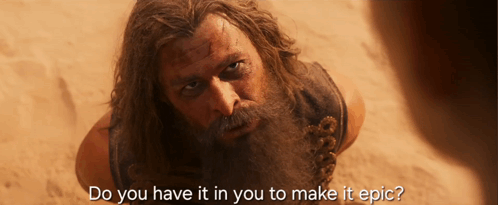 A Man With A Beard Is Laying In The Sand With The Words Do You Have It In You To Make It Epic GIF