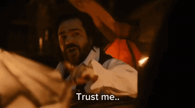 A Man With A Beard Is Laying On A Bed With The Words Trust Me Written Below Him GIF