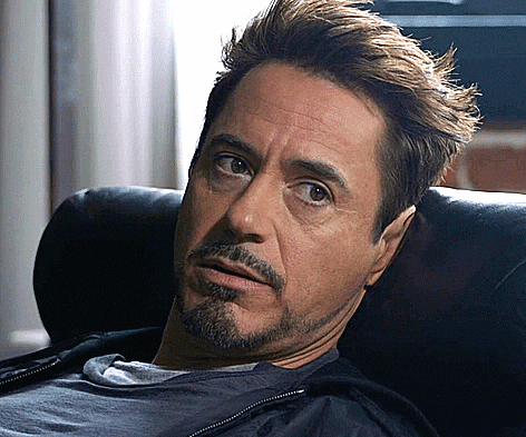 A Man With A Beard Is Laying On A Couch Looking At The Camera GIF