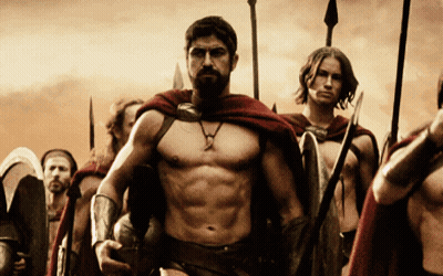 A Man With A Beard Is Leading A Group Of Men With Spears And Shields GIF