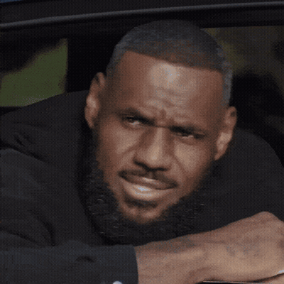 A Man With A Beard Is Leaning On A Table With His Head Resting On His Hand GIF