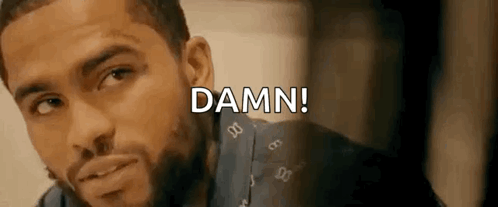 A Man With A Beard Is Looking At The Camera And The Words `` Damn '' Are Written Above Him . GIF