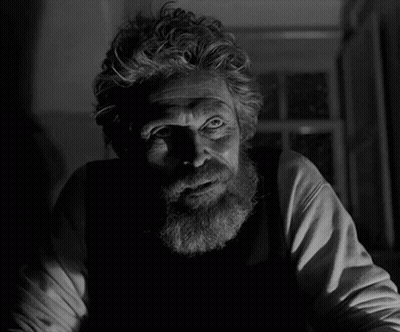 A Man With A Beard Is Looking At The Camera In A Black And White Photo GIF
