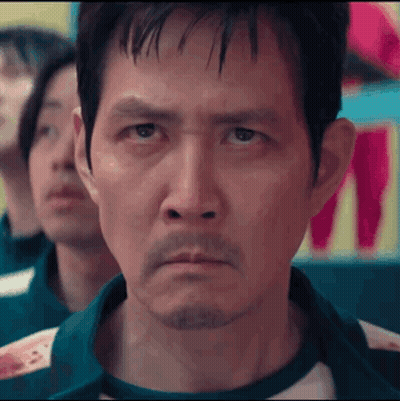 A Man With A Beard Is Looking At The Camera While Playing A Game . GIF