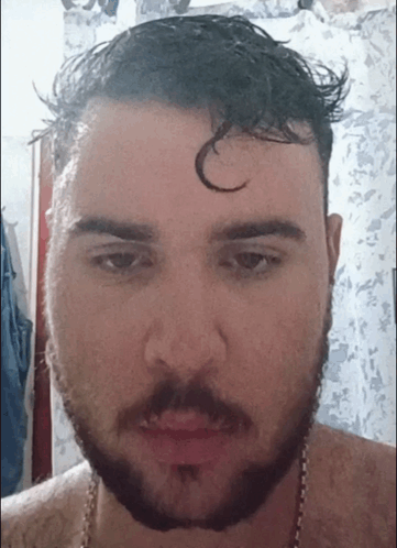 A Man With A Beard Is Looking At The Camera With A C On His Forehead GIF
