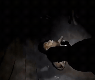 A Man With A Beard Is Looking Up At A Lion In A Cave GIF