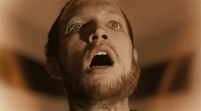 A Man With A Beard Is Looking Up With His Mouth Wide Open GIF