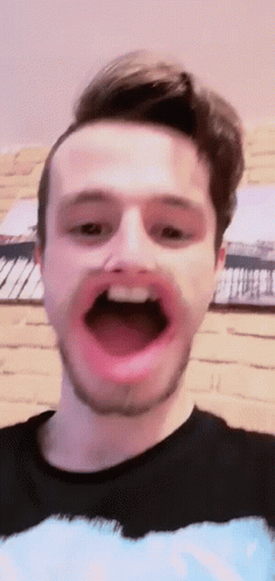 A Man With A Beard Is Making A Face With His Mouth Open . GIF