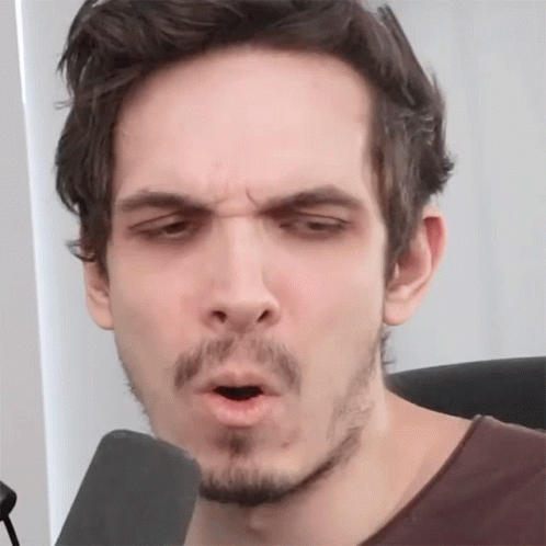 A Man With A Beard Is Making A Face With His Mouth Open GIF