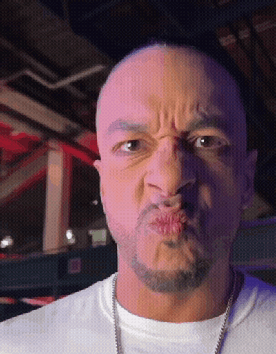 A Man With A Beard Is Making A Face With His Mouth Open GIF