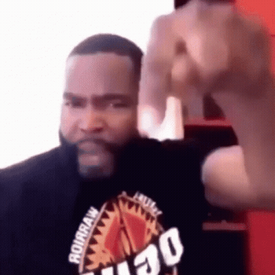 A Man With A Beard Is Making A Funny Face And Giving The Middle Finger . GIF