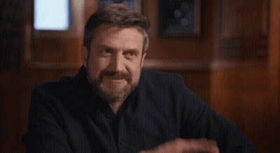 A Man With A Beard Is Making A Funny Face And Pointing GIF
