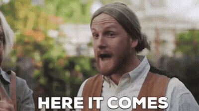 A Man With A Beard Is Making A Funny Face And Says Here It Comes GIF