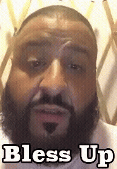 A Man With A Beard Is Making A Funny Face And The Words Bless Up Are On The Bottom Of His Face . GIF