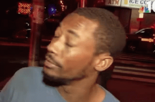 A Man With A Beard Is Making A Funny Face In Front Of An Atm . GIF