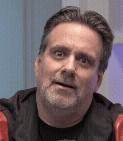A Man With A Beard Is Making A Funny Face While Looking At The Camera . GIF