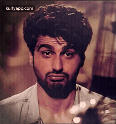 A Man With A Beard Is Making A Funny Face While Looking At The Camera . GIF
